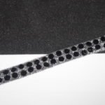 Guarnizione termoadesiva con strass neri. Altezza 0.6 cm.